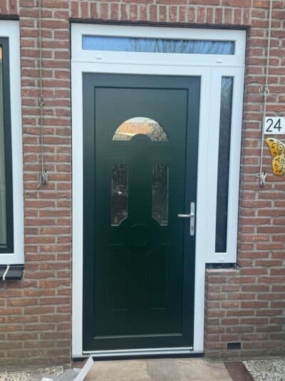 Donkergroene voordeur met halfrond bovenlicht en wit kozijn
