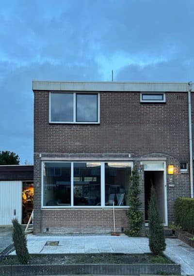 Woning bij schemer met een grote raampartij en nieuwe voordeur